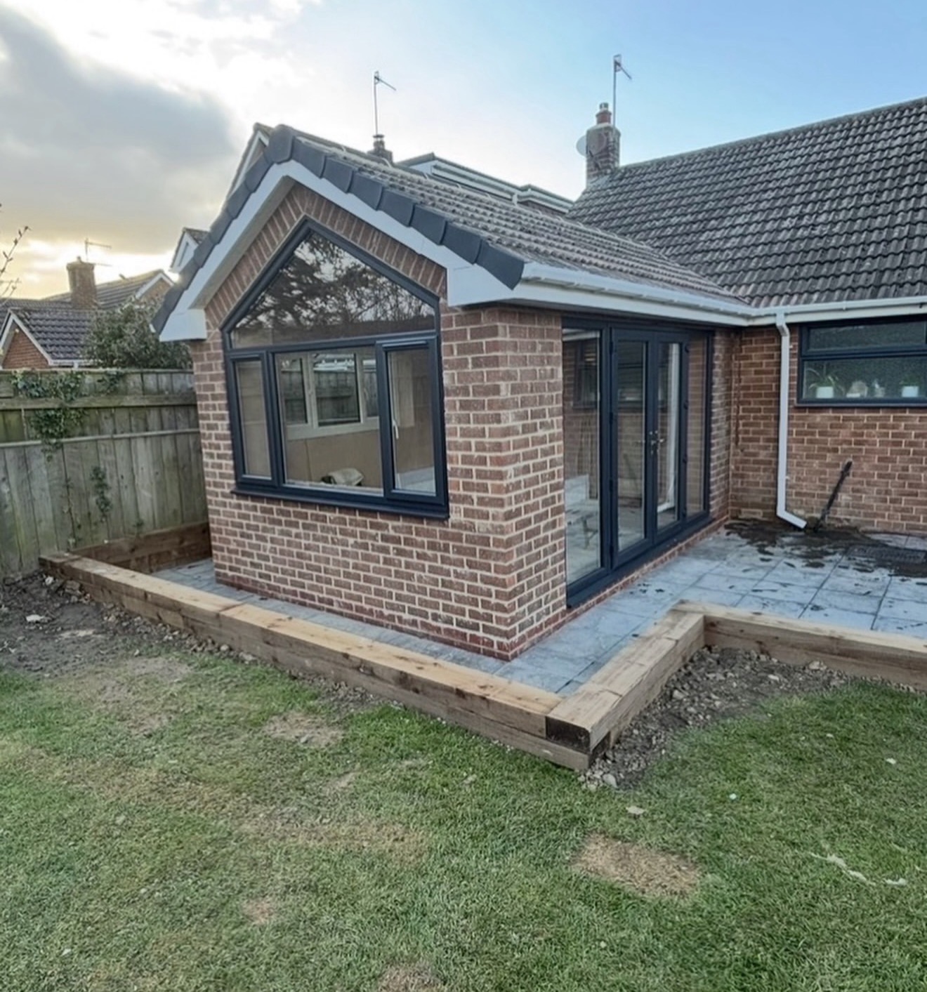 Completed brick rear extension with a gable window and dark bifold doors